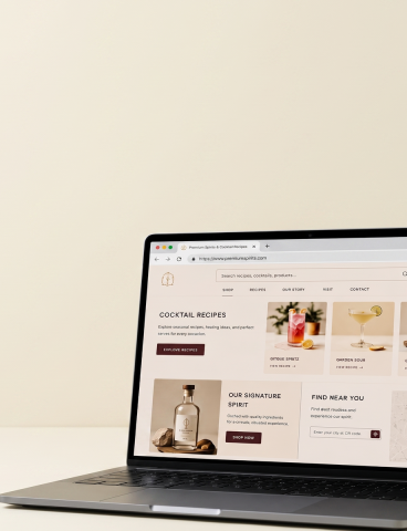 Premium spirits brand Shopify storefront displayed on a laptop showing cocktail recipe hub and product pages built through alcohol SEO strategy