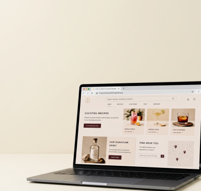 Premium spirits brand Shopify storefront displayed on a laptop showing cocktail recipe hub and product pages built through alcohol SEO strategy